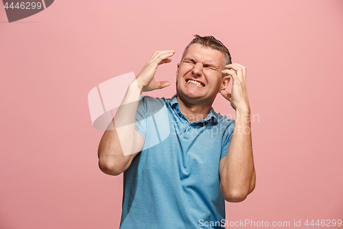 Image of The young emotional angry man screaming on pink studio background