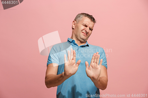 Image of Let me think. Doubtful pensive man with thoughtful expression making choice against pink background