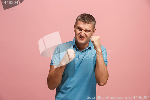 Image of The young emotional angry man screaming on pink studio background