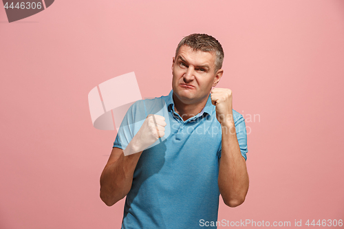 Image of The young emotional angry man screaming on pink studio background