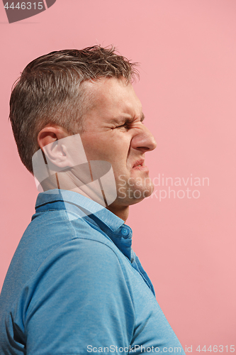 Image of Let me think. Doubtful pensive man with thoughtful expression making choice against pink background