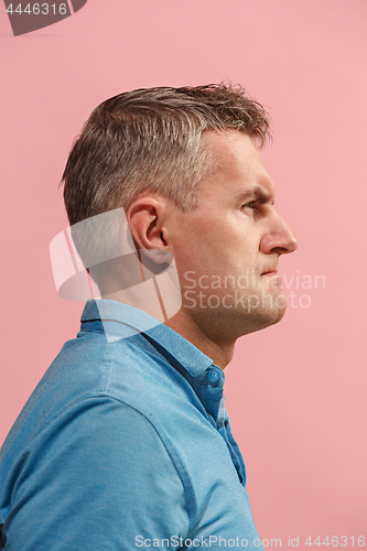 Image of Suspiciont. Doubtful pensive man with thoughtful expression making choice against pink background