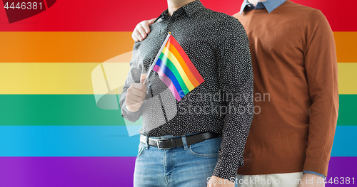 Image of close up of male couple with gay pride flag