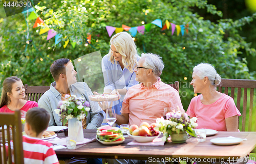 Image of happy family having dinner or summer garden party