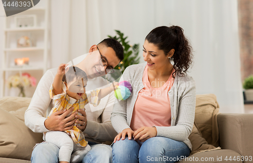 Image of happy family with baby daughter at home