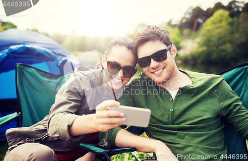 Image of couple of travelers taking selfie by smartphone