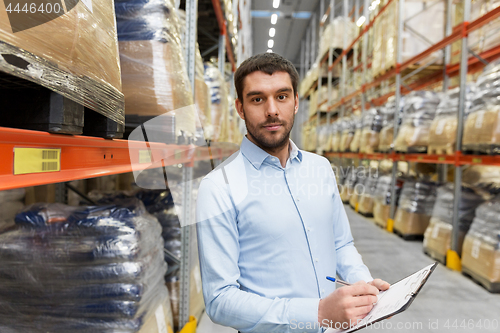 Image of businessman with clipboard at warehouse