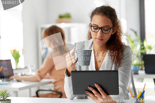 Image of businesswoman with tablet pc and coffee at office