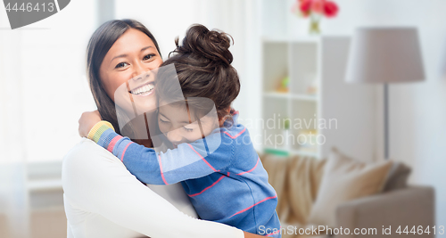 Image of happy mother and daughter hugging at home