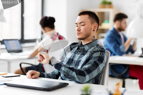 Image of creative man with smart watch working at office