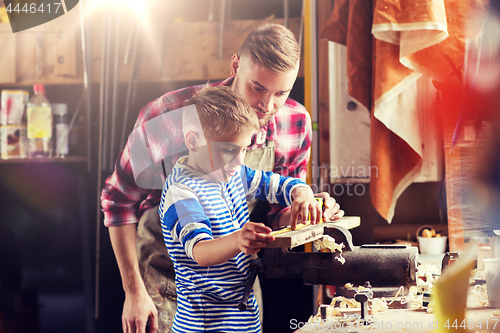 Image of father and son with ruler measure wood at workshop