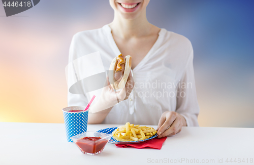 Image of close up of woman eating hotdog and french fries