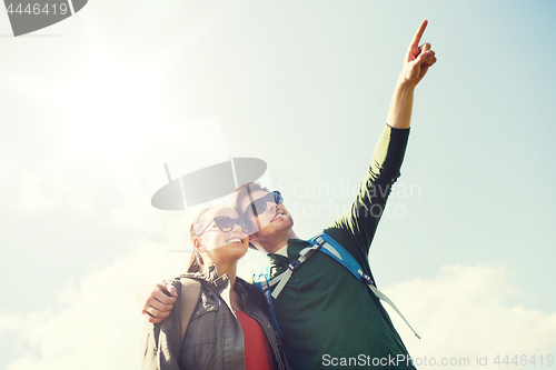 Image of happy couple with backpacks hiking outdoors