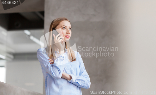 Image of businesswoman calling on smartphone at office