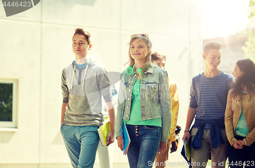 Image of group of happy teenage students walking outdoors