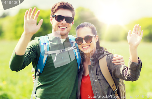 Image of happy couple with backpacks hiking outdoors