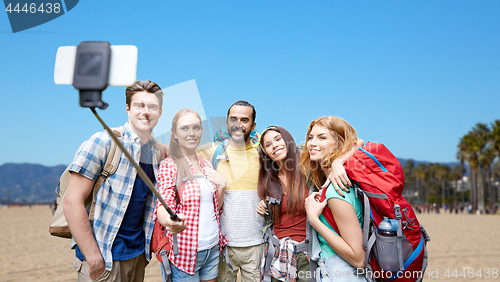 Image of friends with backpacks taking selfie by smartphone