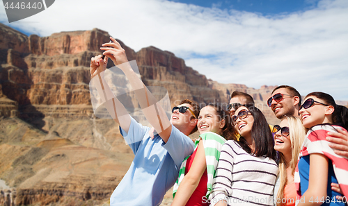 Image of group of happy friends taking selfie by cell phone