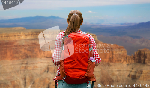 Image of smiling woman with backpack over grand canyon