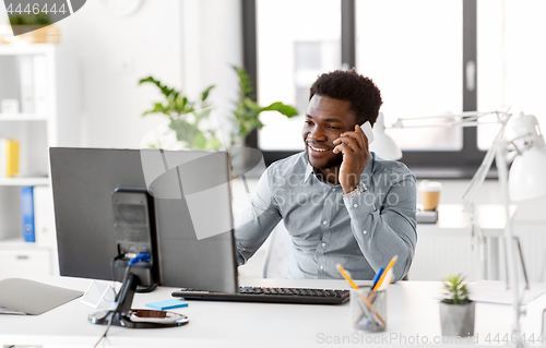 Image of businessman calling on smartphone at office