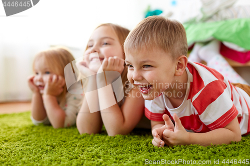 Image of happy little kids lying on floor or carpet