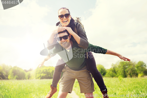 Image of happy couple with backpacks having fun outdoors