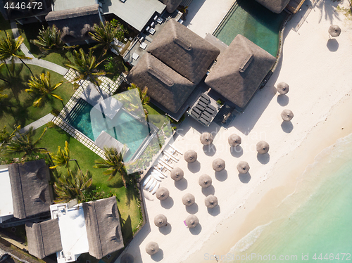 Image of Aerial view of amazing tropical white sandy beach with palm leaves umbrellas and turquoise sea, Mauritius.