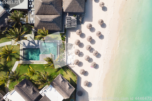 Image of Aerial view of amazing tropical white sandy beach with palm leaves umbrellas and turquoise sea, Mauritius.