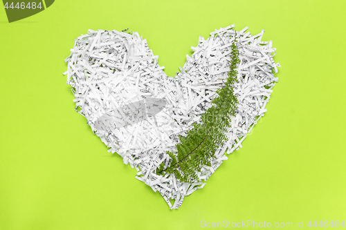 Image of Heart made of shredded paper with a green leaf inside