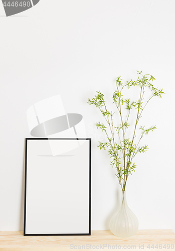 Image of Picture frame and spring tree branches in a vase