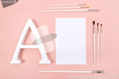 Image of Blank paper, letter A and paintbrushes