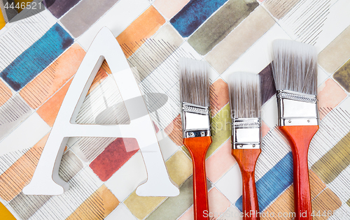 Image of Paint brushes and letter A on watercolor background