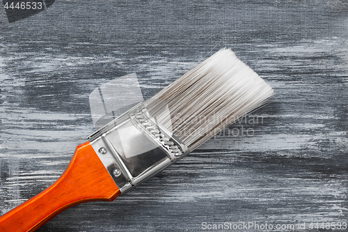 Image of Red paintbrush on gray painted background