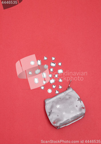 Image of Rhinestones and silver purse on vivid pink background