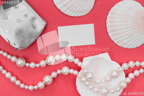 Image of Pearl jewelry and blank card on pink background