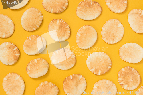 Image of Lots of mini pita bread on yellow background