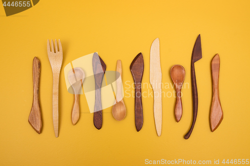 Image of Handcrafted wooden utensils on yellow background