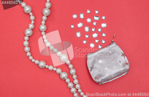 Image of Pearl necklace and silver purse with shiny gems