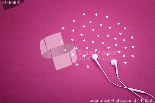 Image of Earphones and hearts on vibrant purple background