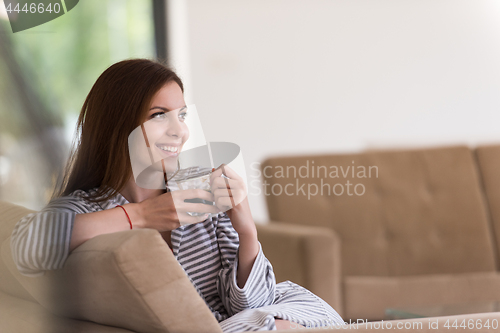 Image of young woman in a bathrobe enjoying morning coffee