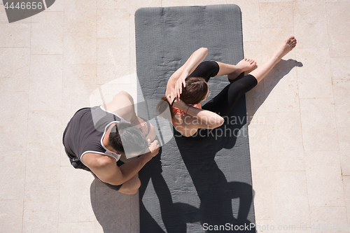 Image of woman with personal trainer doing morning yoga exercises top vie