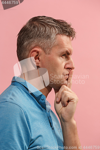 Image of The young man whispering a secret behind her hand over pink background