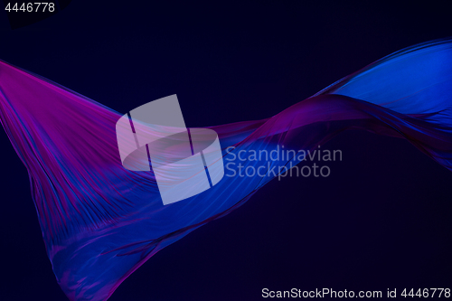 Image of Smooth elegant transparent blue cloth separated on blue background.