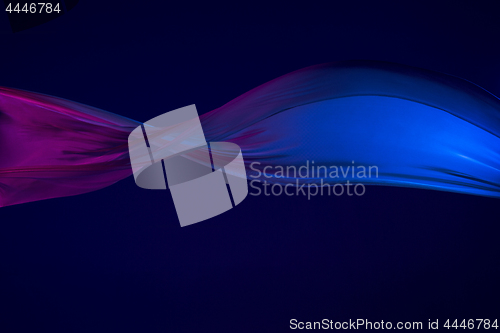 Image of Smooth elegant transparent blue cloth separated on blue background.