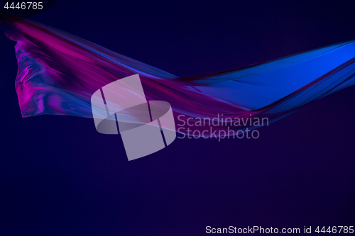 Image of Smooth elegant transparent blue cloth separated on blue background.