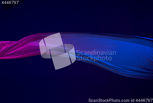 Image of Smooth elegant transparent blue cloth separated on blue background.