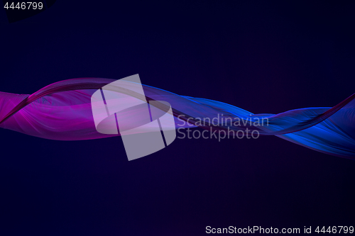 Image of Smooth elegant transparent blue cloth separated on blue background.