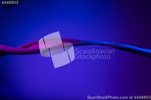 Image of Smooth elegant transparent blue cloth separated on blue background.