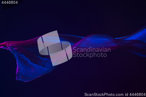 Image of Smooth elegant transparent blue cloth separated on blue background.