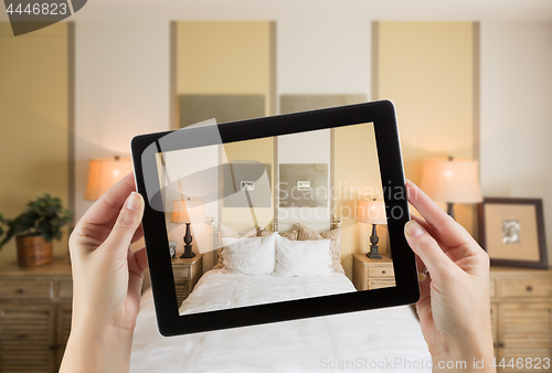 Image of Female Hands Holding Computer Tablet In Room with Photo on Scree